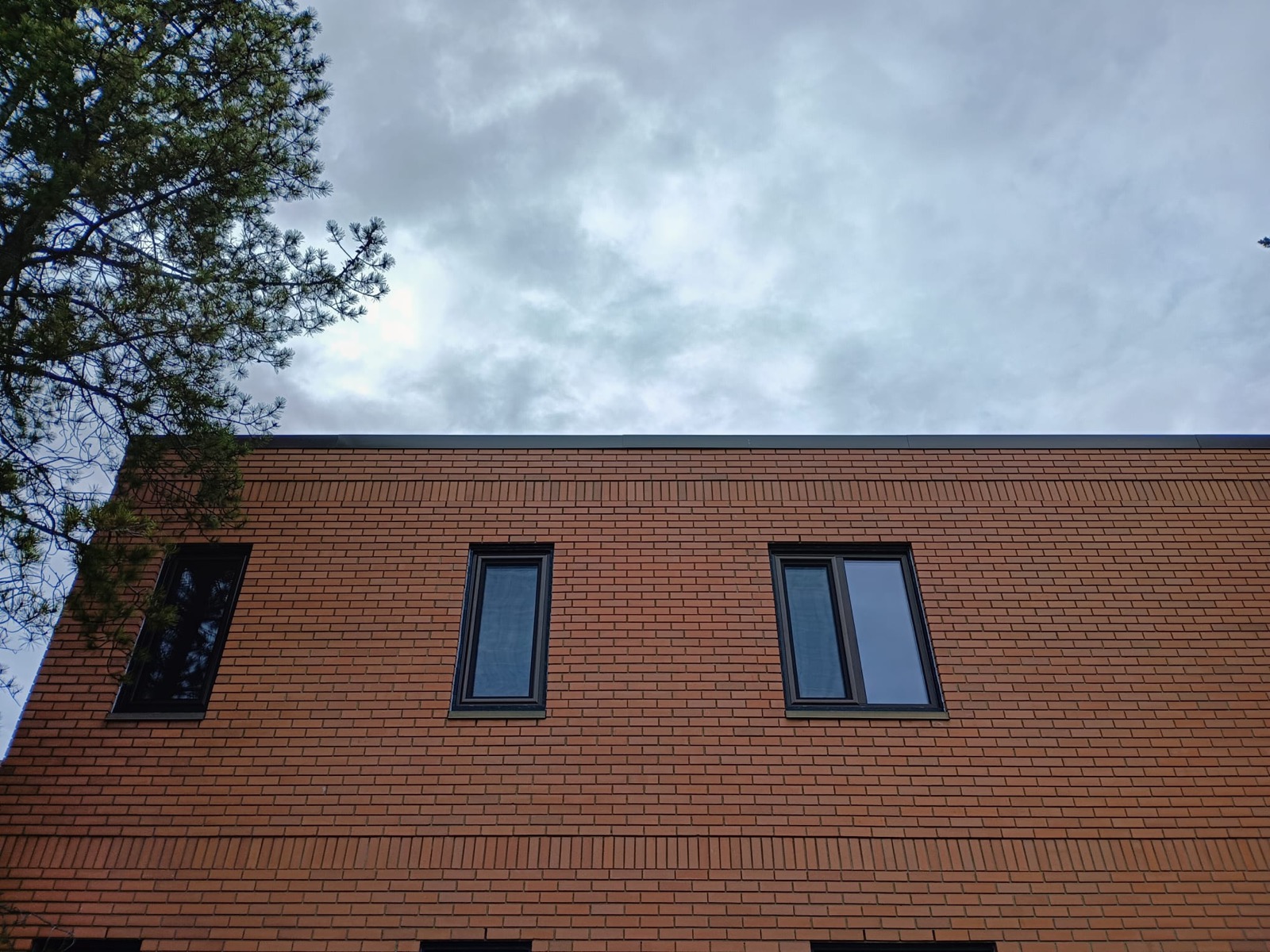 Upper-storey black-frame windows on commercial brick building