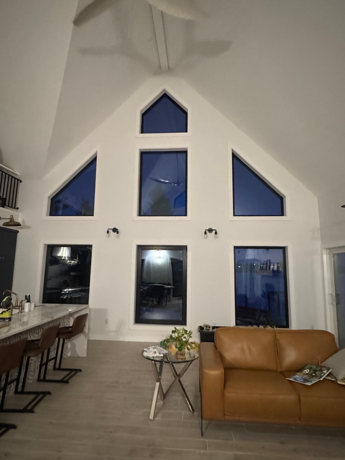 Cathedral great room with custom trapezoid window wall — framing in progress