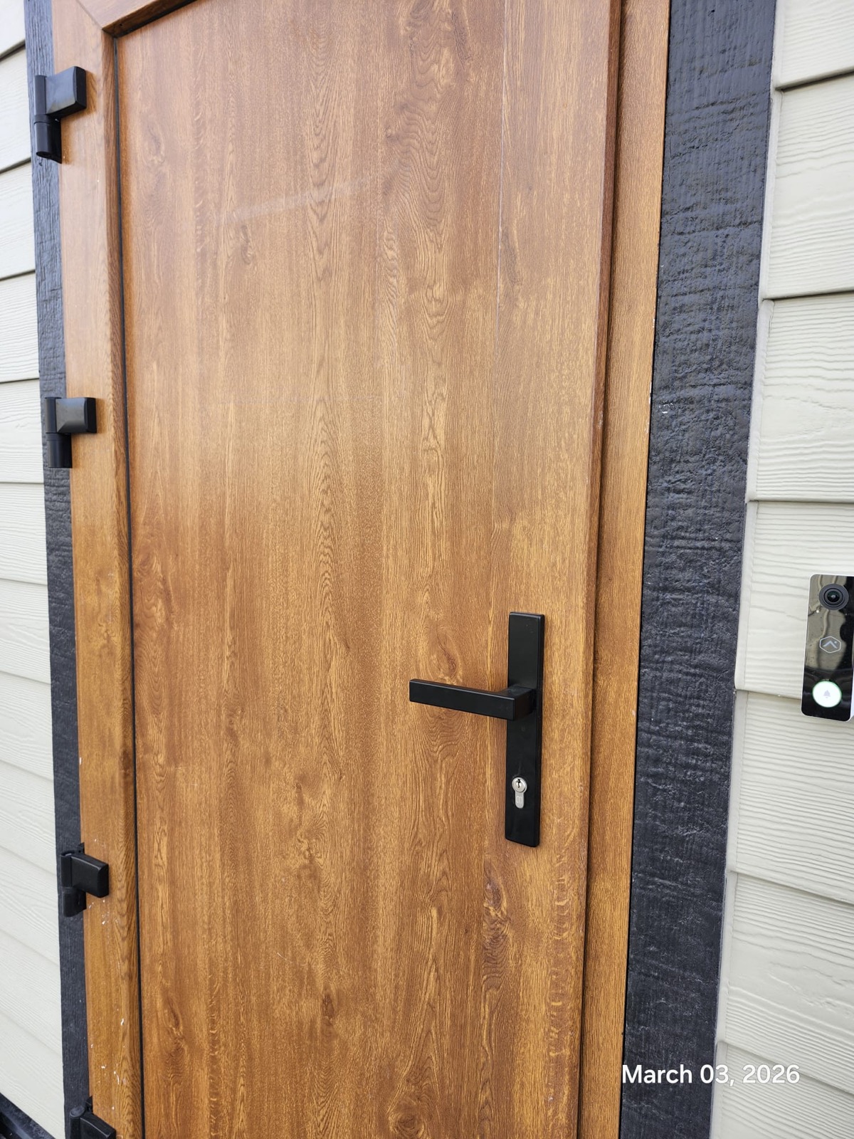 Oak wood-finish entry door with black hardware