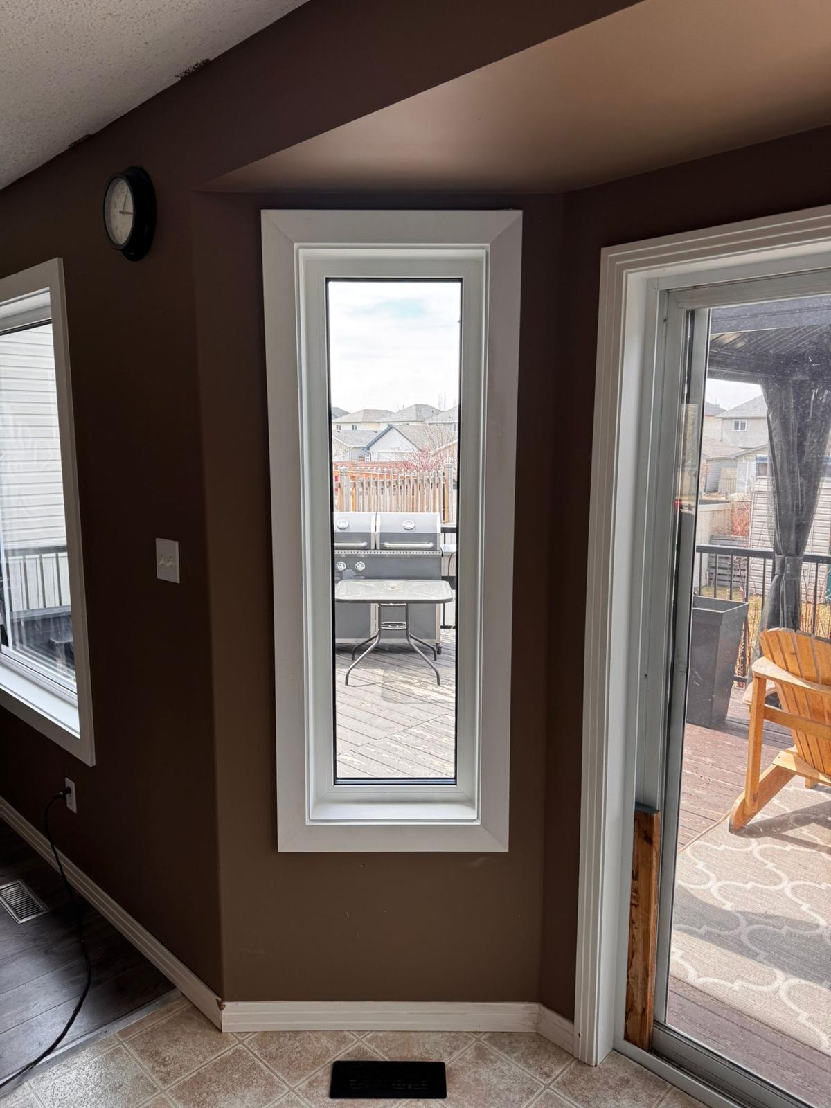 Tall narrow sidelight beside patio door with deck view