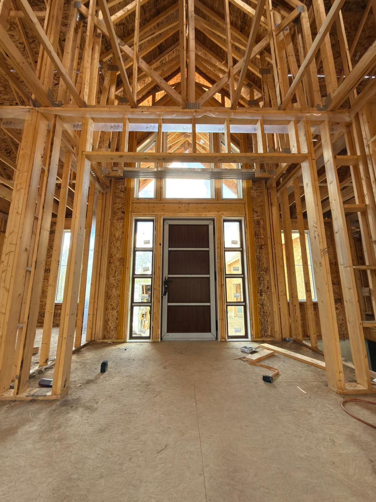 Interior framed entry with door, sidelites and transom under cathedral roof trusses