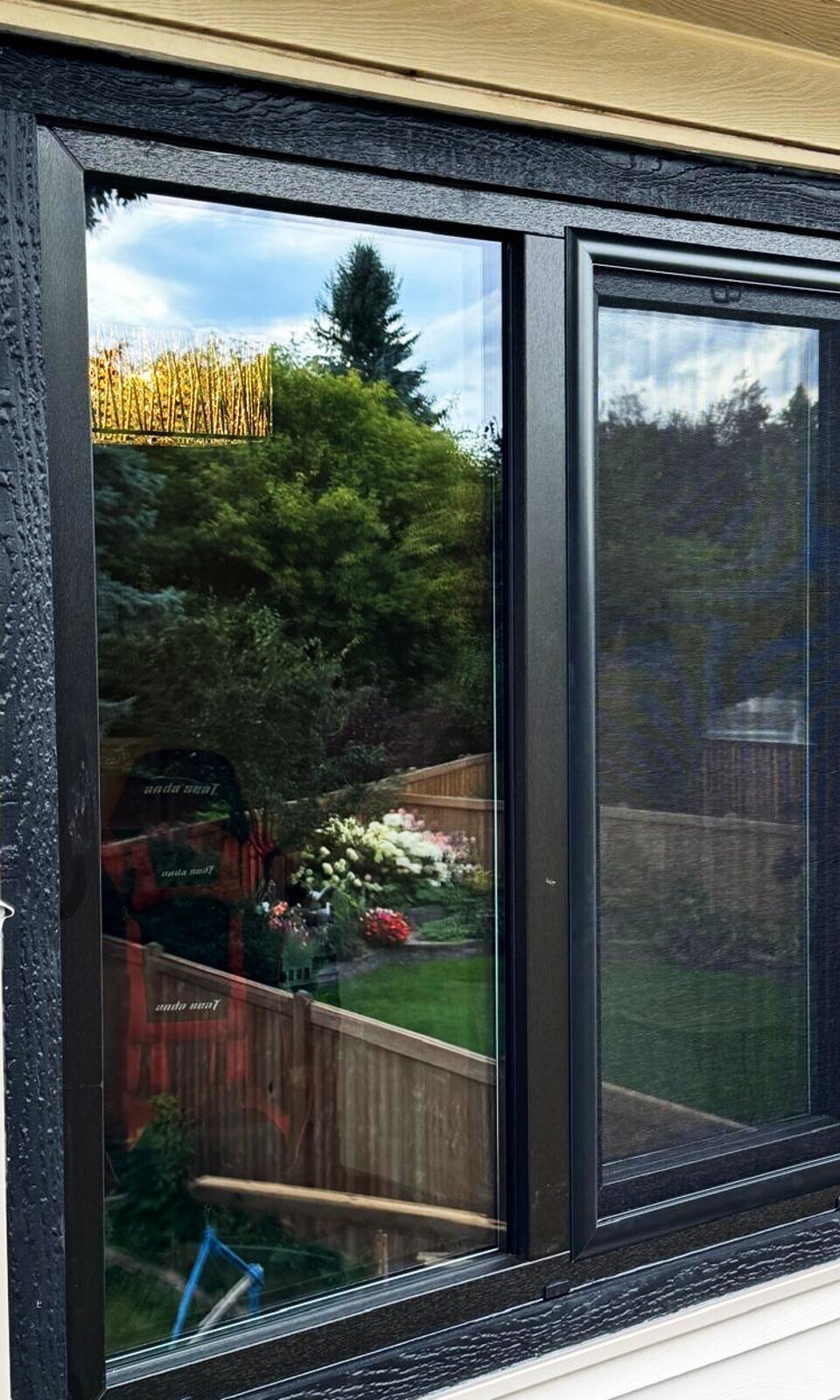 Black tilt-and-turn window, exterior on vinyl siding