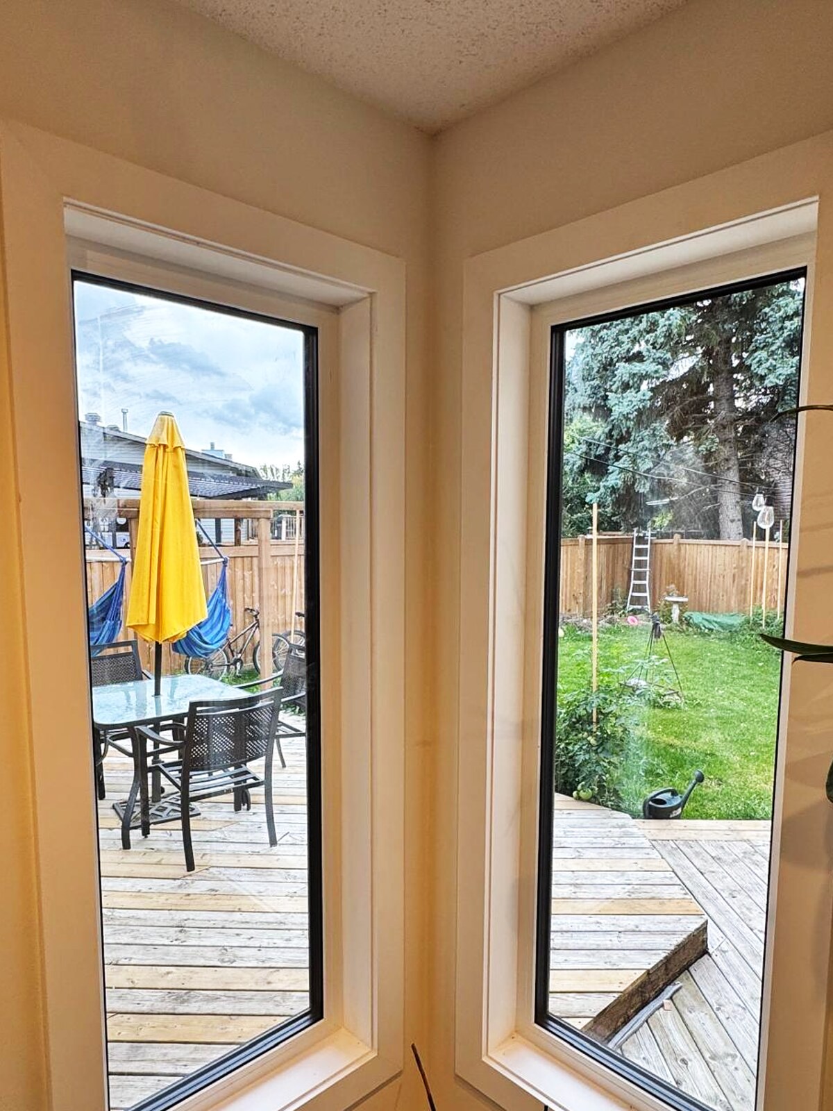Two corner windows, white frames with black glazing bead, deck view