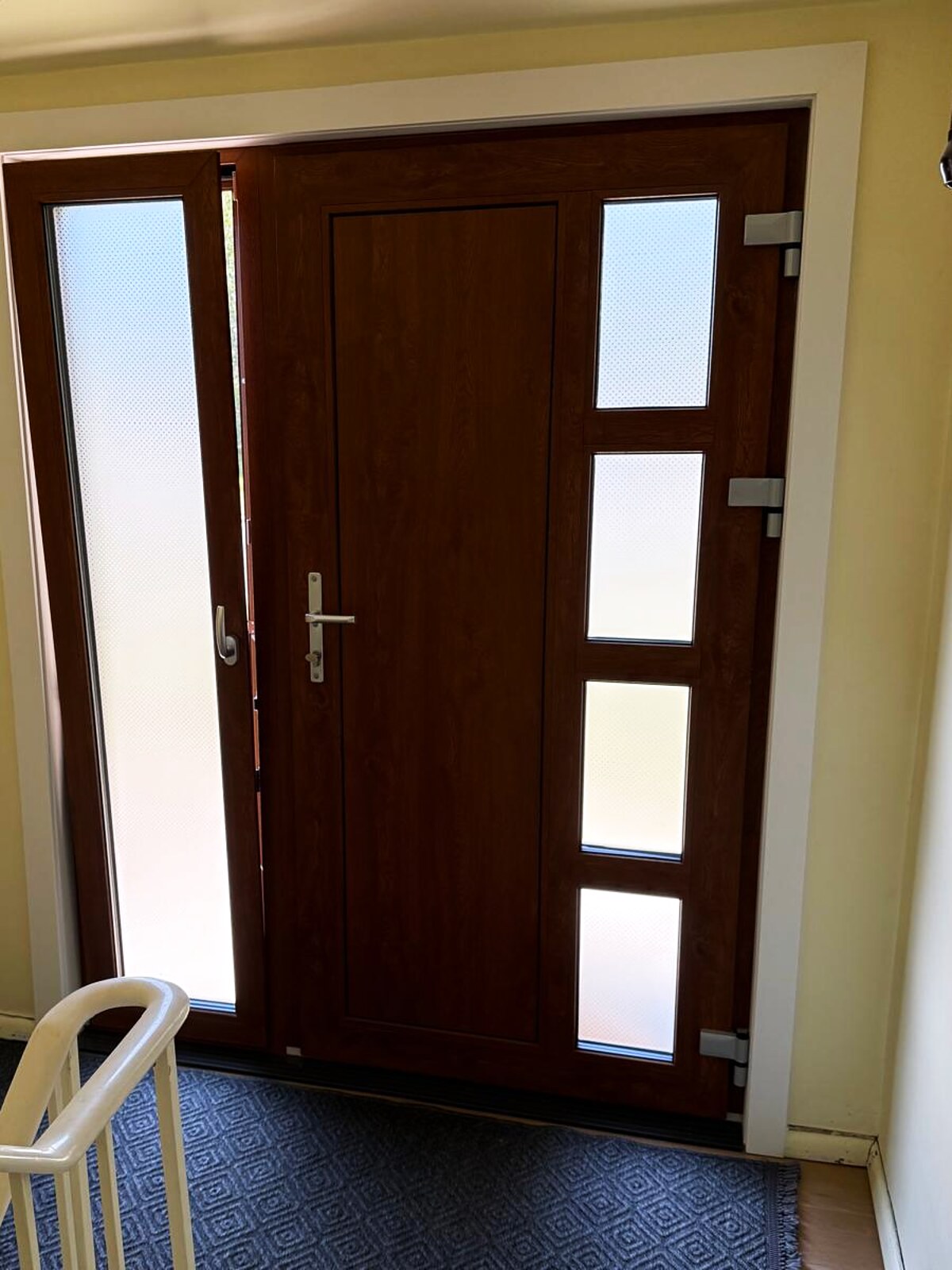 Oak entry door with frosted sidelites, seen from the staircase